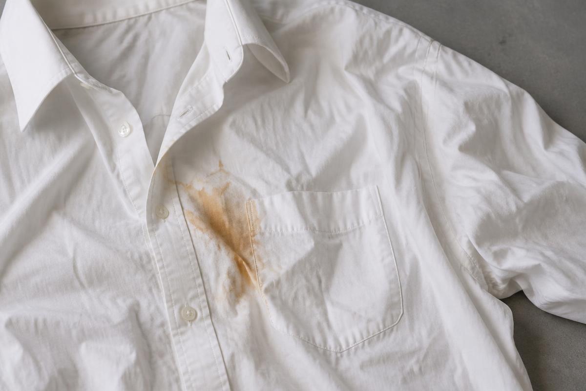 A creased white shirt with a visible stain before cleaning